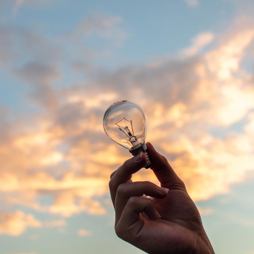 Photo of hand holding light bulb, advisory & facilitation