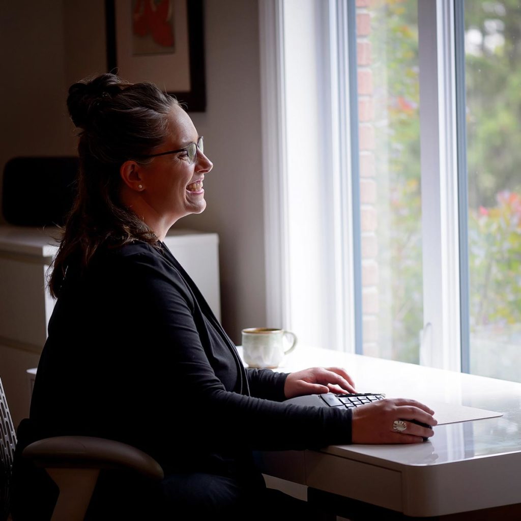 Photo of Saralyn Hodgkin at computer workstation, providing coaching for coaches.